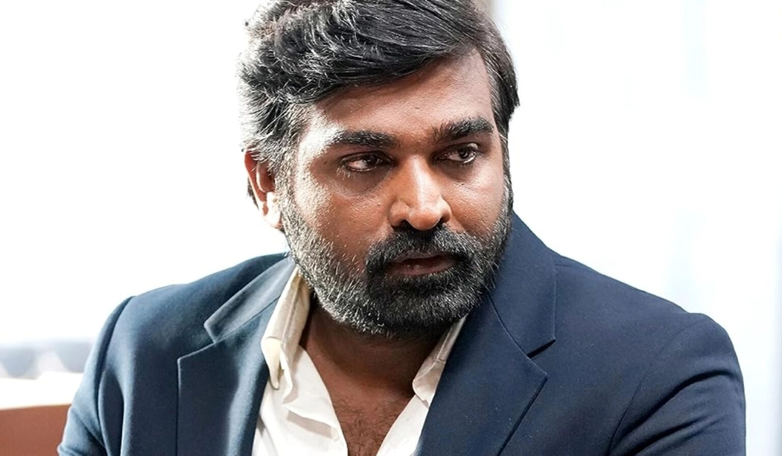 Vijay Sethupathi smiling at a film promotion event in Chennai
