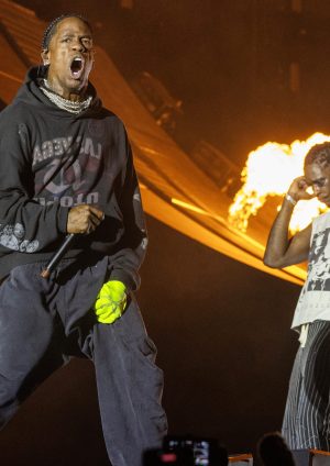 Travis Scott performing live at Mumbai concert with fireworks lighting up the sky