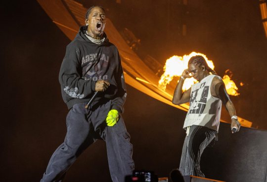 Travis Scott performing live at Mumbai concert with fireworks lighting up the sky
