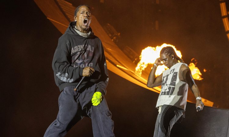 Travis Scott performing live at Mumbai concert with fireworks lighting up the sky
