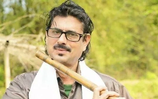 Deepak Sarma playing the flute during a live performance in Assam