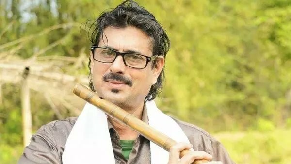 Deepak Sarma playing the flute during a live performance in Assam